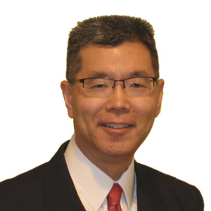 headshot of a smiling man wearing classes