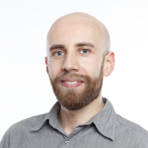 head shot of smiling man with a bald head and short beard