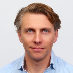 Headshot of a smiling man with short hair in collard shirt