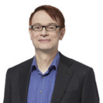 headshot of smiling man with short dark hair and glasses