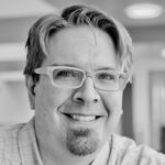 Headshot of smiling man with glasses