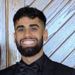 Headshot of smiling man with dark hair and beard