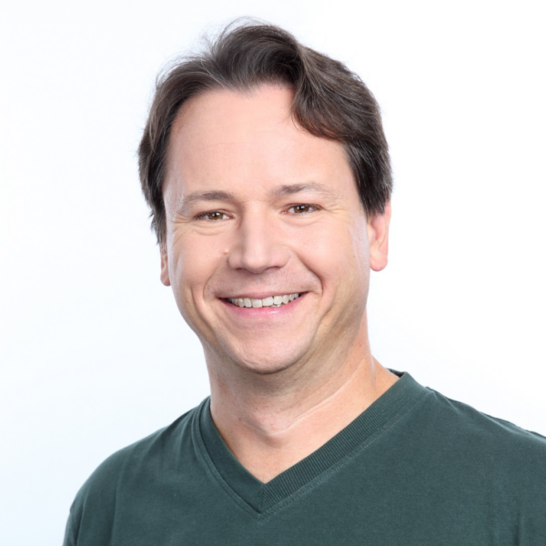 headshot of smiling man with short dark hair