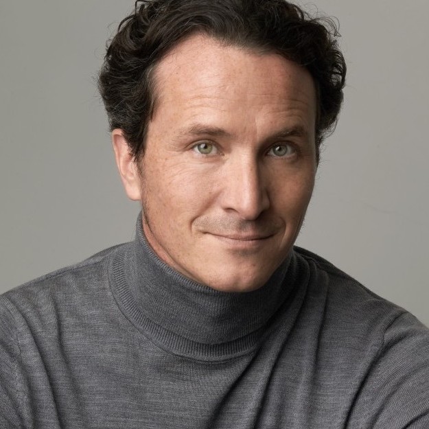 Headshot of smiling man with short dark hair