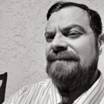 B&W headshot of man with beard.